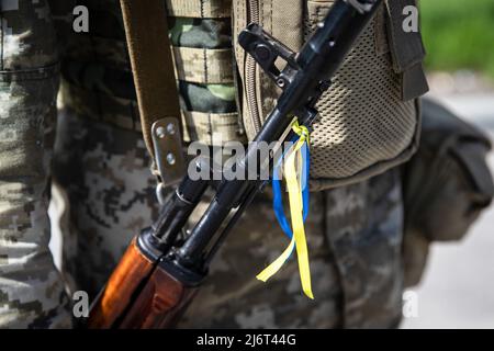 25 avril 2022, Kharkiv, Ukraine : un soldat ukrainien tient son fusil avec des rubans aux couleurs nationales de l'Ukraine dans l'oblast de Kharkiv. Alors que la guerre entre l'Ukraine et la Russie fait rage depuis plus de deux mois, la Russie a maintenant déplacé son objectif tactique vers la partie orientale de l'Ukraine et a maintenant concentré l'offensive sur la partie orientale du pays. L’oblast de Kharkiv fait désormais l’objet d’une menace constante de bombardements et de frappes aériennes russes. La Russie a envahi l'Ukraine le 24 février 2022, déclenchant la plus grande attaque militaire en Europe depuis la Seconde Guerre mondiale (Image de crédit : © Alex Chan TSZ Yuk/SOPA Images via ZUMA Press Wire) Banque D'Images