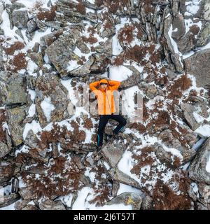 Le touriste se trouve sur un rocher près du mont Petros, vêtements lumineux pour les touristes. Banque D'Images