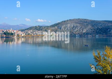 Vue sur la ville de Kastoria reflétée dans le lac Orestiada et un bateau, Grèce Banque D'Images