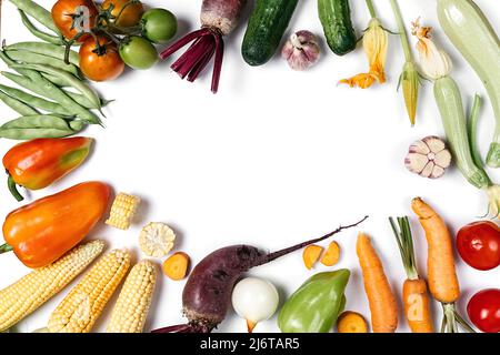 Mise en page créative faite de légumes d'automne. Tomates, oignon, concombre, carotte, ail, betterave rouge, poivre, courgettes, maïs et haricot vert sur stu blanc Banque D'Images