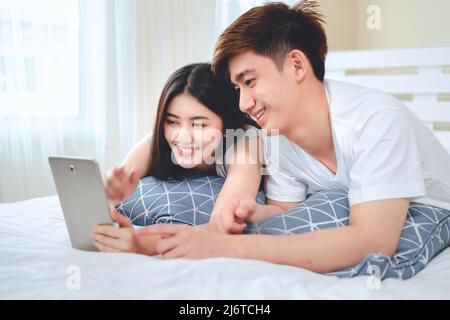 un couple asiatique utilisant une tablette ou un ordinateur démarre une entreprise vendant des produits en ligne. Banque D'Images