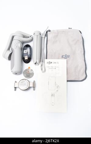 Fuji City, Shizuoka-Ken, Japon - 31 décembre 2021 : stabilisateur et accessoires pour smartphone DJI OM 5 en vue de dessus isolés sur fond blanc dégradé. Banque D'Images