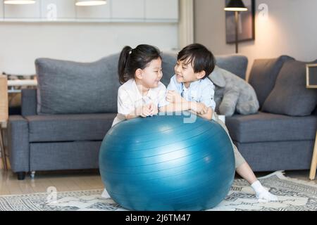 Un garçon et une fille jouant intimement dans le salon de leur maison - photo de stock Banque D'Images