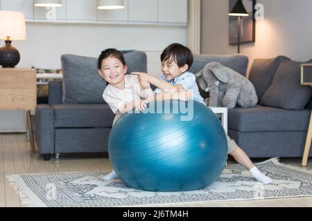 Un garçon et une fille jouant intimement dans le salon de leur maison - photo de stock Banque D'Images