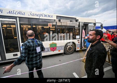 Des volontaires et des journalistes accueillent les habitants de Marioupol, y compris les évacués d'Azovstal qui ont passé près de deux mois dans le refuge des aciéries, au Centre d'enregistrement des personnes déplacées de Zaporizhzhia, dans le sud-est de l'Ukraine, le 3 mai 2022. Des civils évacués de l'aciérie assiégée d'Azovstal à Marioupol ont décrit leur épreuve de violence après leur arrivée dans la ville ukrainienne de Zaporizhzhia. Leur arrivée a également été confirmée par le Bureau de la coordination des affaires humanitaires (OCHA). Après avoir descendre des bus, les évacués se sont dirigés vers des tentes que le gouvernement ukrainien a établies Banque D'Images