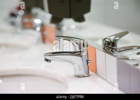 Gros plan vieux acier inoxydable Chrome robinet salle de bains et poussière sur la surface ne pas nettoyer et capteur pour l'ouverture et fermeture automatique de l'alimentation en eau Banque D'Images