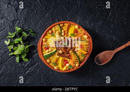 Couscous à la viande et aux légumes, dîner marocain festif, plan d'écran plat avec espace de copie sur fond noir Banque D'Images