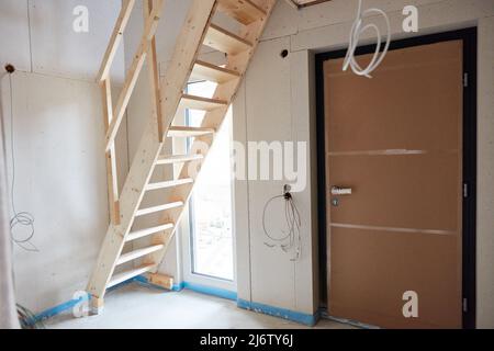 Construction temporaire escaliers en bois lors de la construction d'une maison dans le couloir à la porte d'entrée Banque D'Images