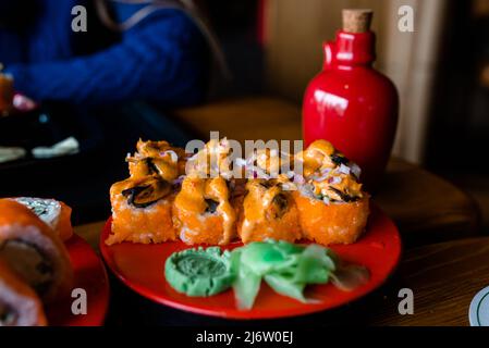 Art culinaire, fruits de mer traditionnels, photo du menu du restaurant. Un délicieux lot de petits pains maki à sushis japonais servis sur une assiette ronde, à concentration sélective Banque D'Images