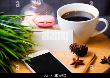 Bureau table avec smartphone, stylo sur ordinateur portable, carte de visite, tasse de café et fleur. Vue de dessus avec espace de copie Banque D'Images