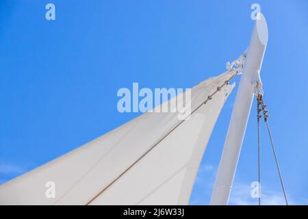 L'auvent blanc en forme de voile est sous le ciel bleu, fond de station balnéaire Banque D'Images