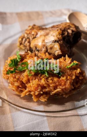 Nourriture nigériane : riz Jollof avec poulet frit en gros plan sur une assiette. Photo verticale Banque D'Images