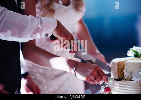 Couple Hands Cutting Wedding Cake, Bride and Wedding ceremonies. Banque D'Images