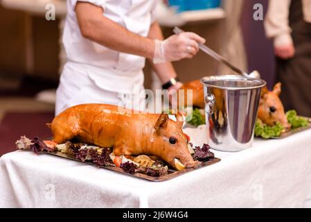 Rôti de porc. Porcelet rôti avec légumes sur le plateau. Banque D'Images