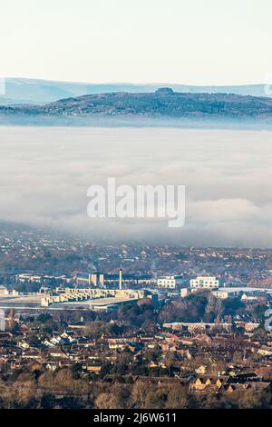 Une inversion de température qui provoque un brouillard pour obscurcir la ville de Gloucester, Angleterre Royaume-Uni. Le parc d'activités de Gloucester à Brockworth est en premier plan et en mai Banque D'Images