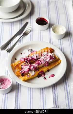 Pancakes farcis frits. Crêpes russes fines avec fromage cottage, crème sure et confiture. Petit déjeuner traditionnel sain. Crêpes fourrées savoureuses c Banque D'Images