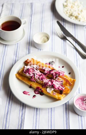Pancakes farcis frits. Crêpes russes fines avec fromage cottage, crème sure et confiture. Petit déjeuner traditionnel sain. Crêpes fourrées savoureuses c Banque D'Images