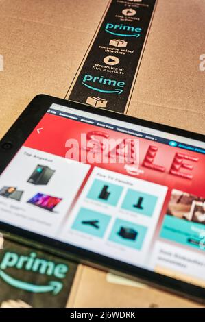 Berlin, Allemagne - 12 janvier 2021 : logo d'une société mondiale de vente par correspondance sur un paquet. Une tablette avec le site Web du fournisseur se trouve sur l'emballage. Banque D'Images