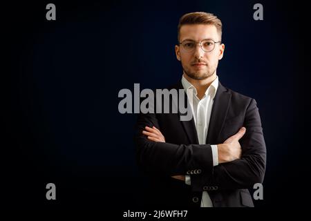 Portrait d'un homme d'affaires en costume sur fond sombre. Banque D'Images