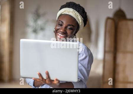 Femme afro-américaine travaillant sur un ordinateur portable à domicile Banque D'Images