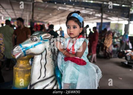 Un enfant vu en train de profiter d'une promenade dans un parc d'attractions pendant les vacances d'Eid. Sans aucune restriction, tous les centres d'amusement ouverts pour accueillir plus de personnes pour la première fois depuis que Covid-19 a frappé le pays, le gouvernement a permis aux lieux touristiques, les centres communautaires et les parcs d'attractions de reprendre les services. (Photo de Sazzad Hossain / SOPA Images / Sipa USA) Banque D'Images