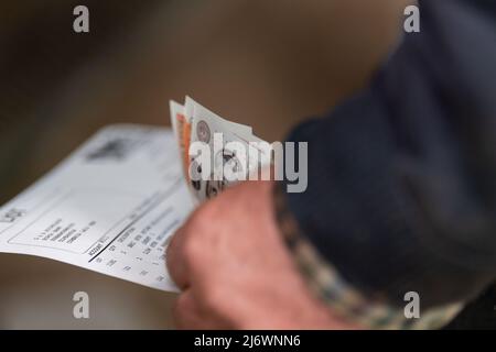 Agriculteur avec de l'argent dans ses mains après une vente aux enchères de marché. Cumbria, Royaume-Uni. Banque D'Images