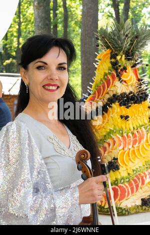 Portrait d'un violoniste avec un concert de flûte à violon sur fond de gâteau aux fruits. Banque D'Images