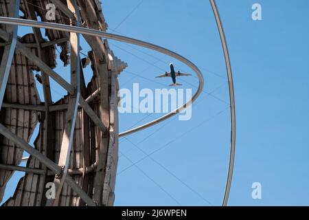 Un avion qui part de l'aéroport LaGuardia dans Queens, vu à travers Unisphere dans le parc Corona de Flushing Meadows. Banque D'Images