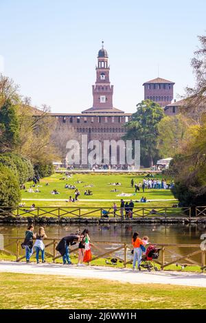 Milanese et les touristes apprécient le Parco Sempione (parc du Simplon) à Milan, en Italie, surplombez les tours du Castello Sforzesco (château de Sforza). Banque D'Images