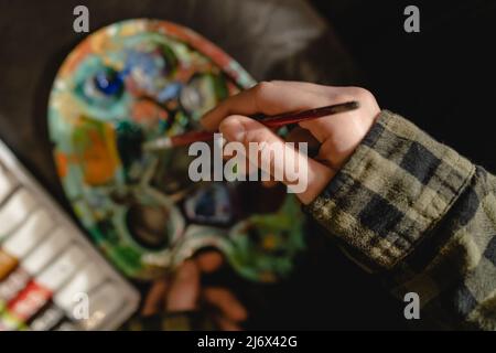 Gros plan sur les mains d'artiste peintre inconnu féminin avec palette de couleurs et pinceaux prêts à faire de l'art de loisirs professionnel ou ama Banque D'Images