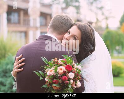 couple de mariage (femme et homme) en robe de mariage et costume regardant le coucher du soleil sur le terrain. L'amour, la famille, la tendresse concept Banque D'Images