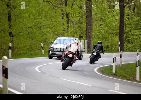 Deux motocyclistes sur une route de campagne photographiés dans la forêt du Palatinat, en Allemagne Banque D'Images