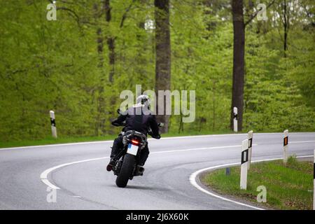 Motocycliste sur une route de campagne photographiée dans la forêt du Palatinat, en Allemagne Banque D'Images