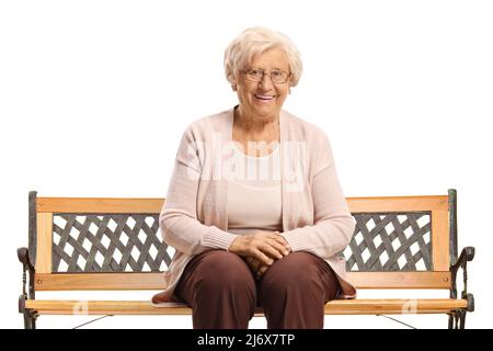 Femme âgée assise sur un banc et souriante isolée sur fond blanc Banque D'Images