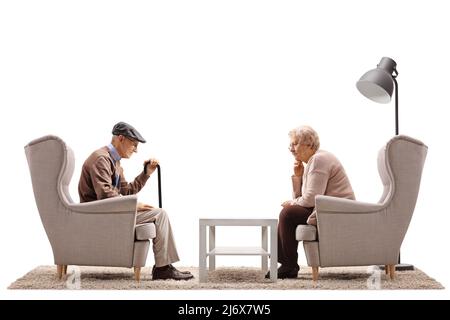 Triste homme âgé et femme assis dans des fauteuils isolés sur fond blanc Banque D'Images