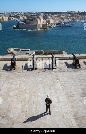 Un soldat solitaire à la batterie saltante avec vue sur le Grand Port jusqu'au fort Saint-Ange, à la Valette, à Malte Banque D'Images