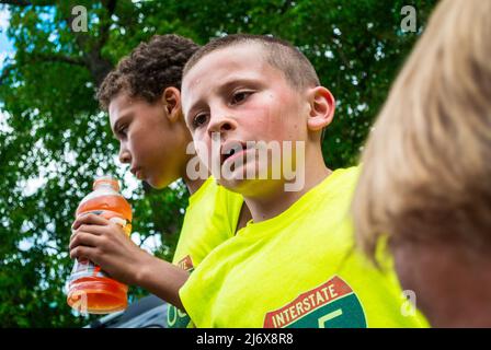 Un garçon de neuf ans fait une pause lors du tournoi de basketball Gusmacker trois sur trois de 2017 à Ludington, Michigan, États-Unis. Banque D'Images