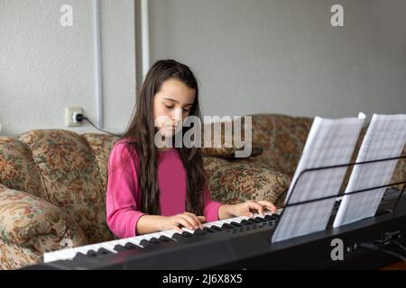 petite fille jouant sur un nouveau synthétiseur dans la vieille chambre Banque D'Images