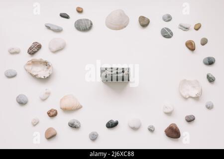 Savon biologique naturel avec coquillages et pierres sur fond blanc. Concept spa. Flat lay, vue de dessus Banque D'Images