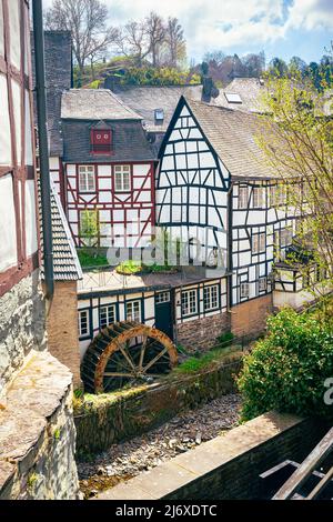 Ancienne roue à aubes et maisons traditionnelles allemandes à colombages le long de la rivière Ruhr dans la ville historique de Monschau, Allemagne Banque D'Images