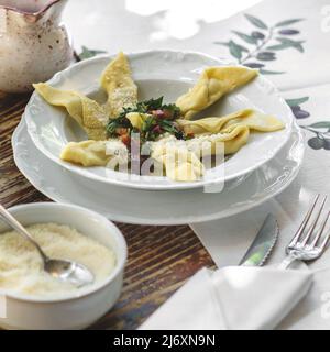 Délicieux Casoncelli italien servi sur une table rustique en bois avec du pain maison et du vin rouge. Casoncelli alla Bergamasca. Restaurant italien typique. F Banque D'Images