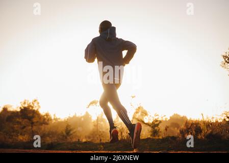 Coureur kenyan, silhouette au coucher du soleil. Surface blanche en arrière-plan Banque D'Images