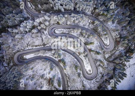 Vue aérienne par drone d'une belle route de montagne en Roumanie en hiver Banque D'Images