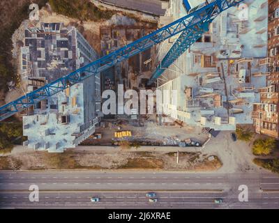 Site de construction ci-dessus. Vue aérienne du nouvel appartement en construction. Vue de dessus du bâtiment sur la route. Sous le chantier de construction, grue, et Banque D'Images