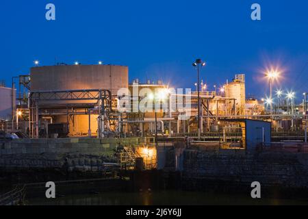 Réservoirs de stockage de pétrole dans une raffinerie de pétrole et de gaz illuminés au crépuscule, Montréal, Québec, Canada. Banque D'Images