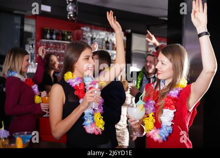 Deux femmes à la fête hawaïenne à la discothèque Banque D'Images