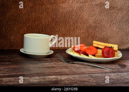 Gaufres belges avec fraises et bananes avec une tasse de café noir sur une table en bois. Gros plan. Banque D'Images