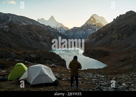 photographe de camping asiatique prenant une photo de la montagne et du lac dans le parc national de yading, comté de daocheng, province du sichuan, chine Banque D'Images