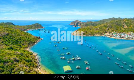 Vinh Hy Bay vue d'en haut à midi en été avec des centaines de bateaux de pêche amarrés et des villages de pêche en bas. Banque D'Images