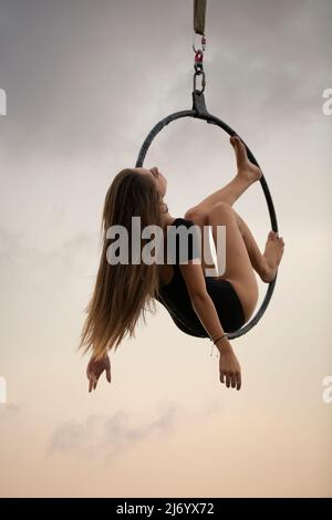 Une femme aerialiste se portant sur un panier Banque D'Images